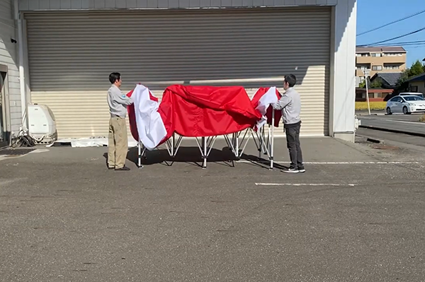 フレームを半分ほど広げて天幕を被せ、四隅をマジックテープで固定する